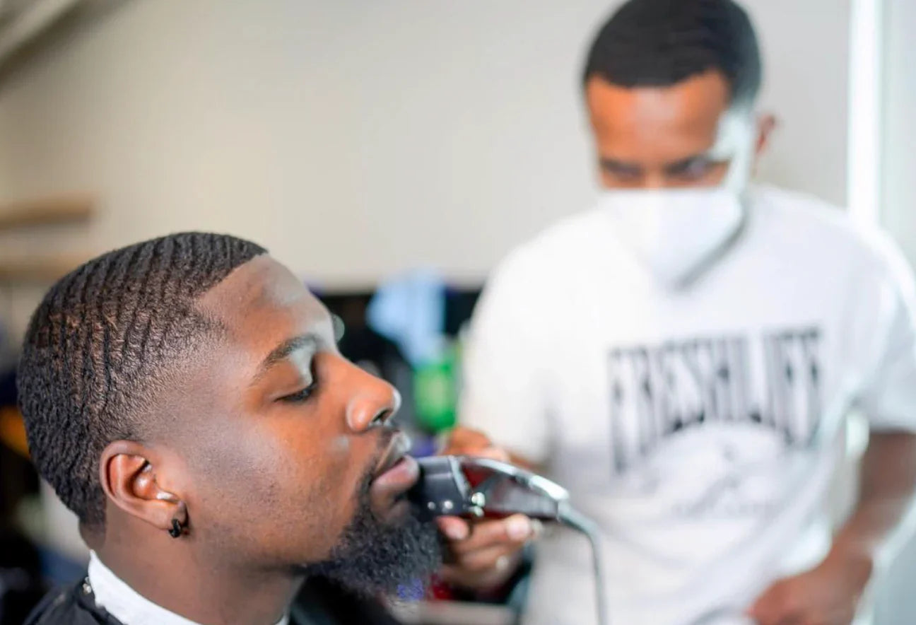 a barber cutting a waver with a 360 waves hairstyle