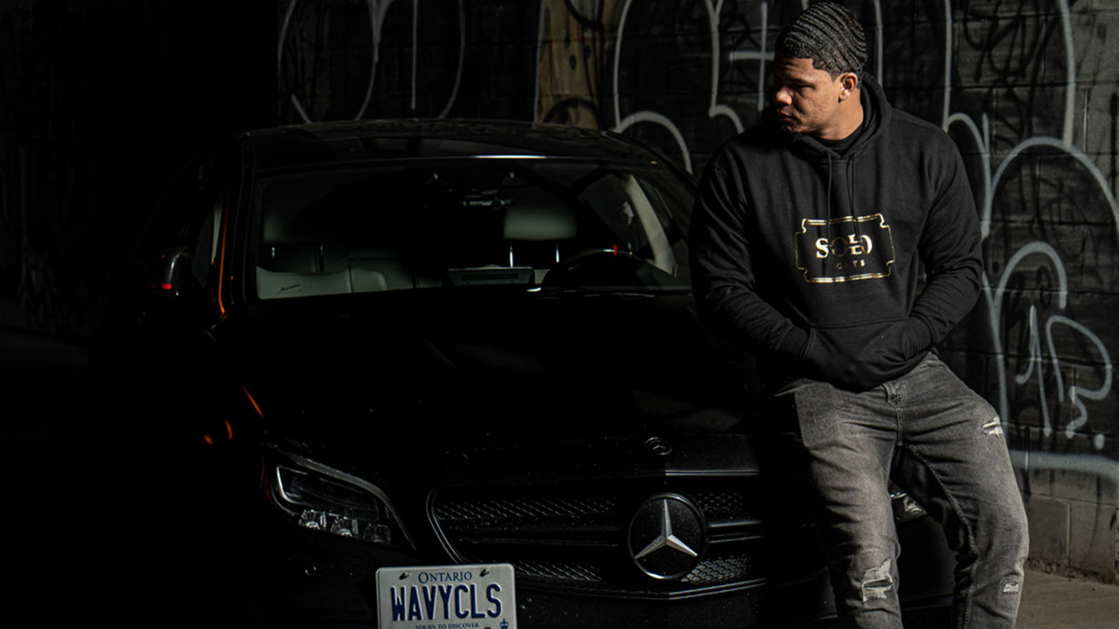 A model with deep 360 waves sitting on a Mercedes Benz