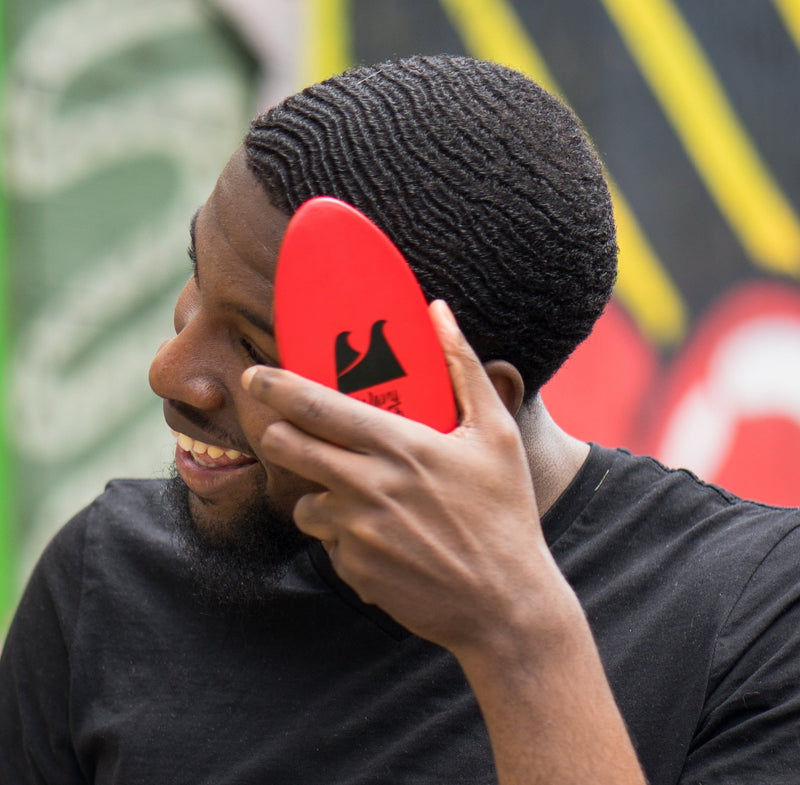 Person holding an inferno soft wave brush on their 360 waves hairstyle