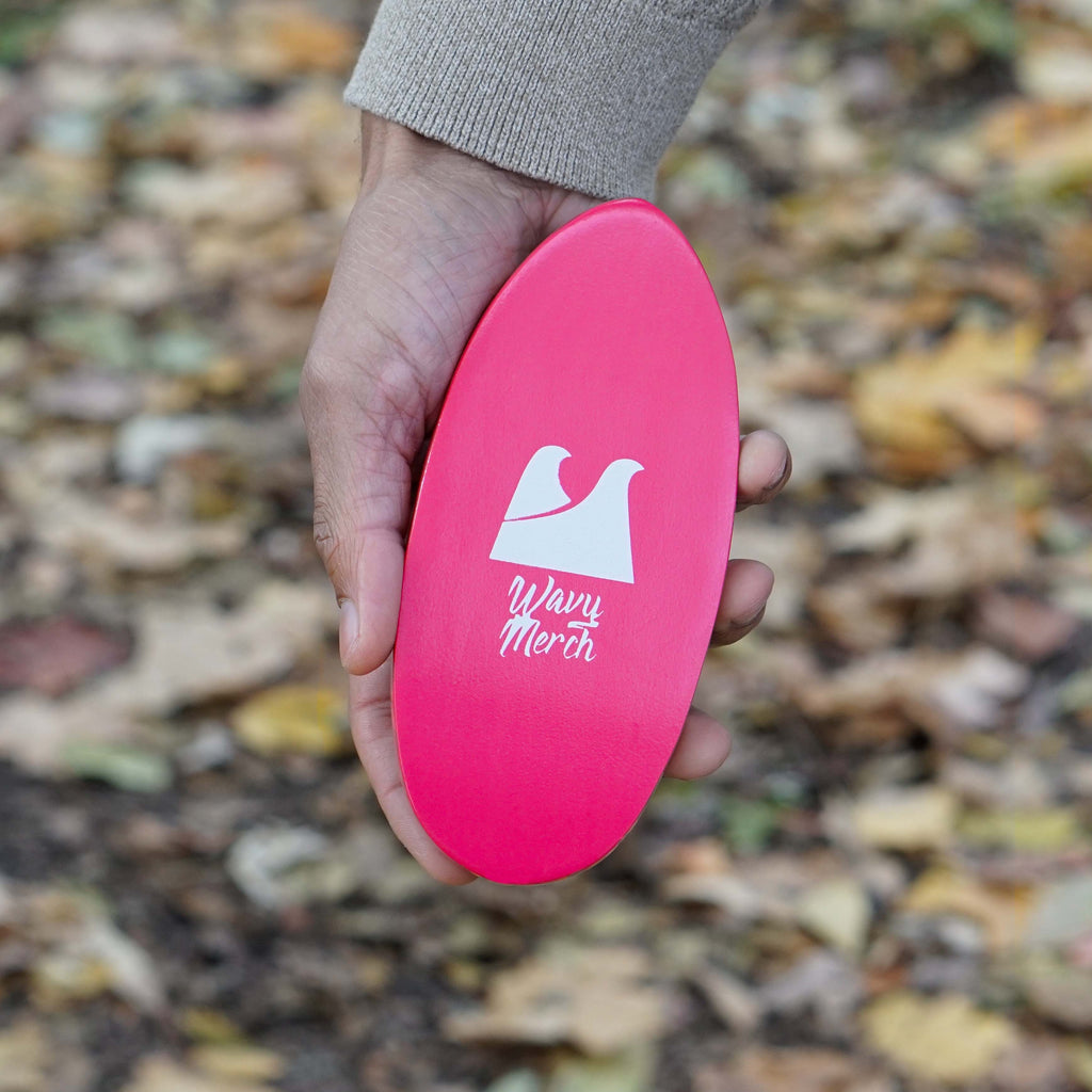 a hand holding the pink rosé hard wave brush