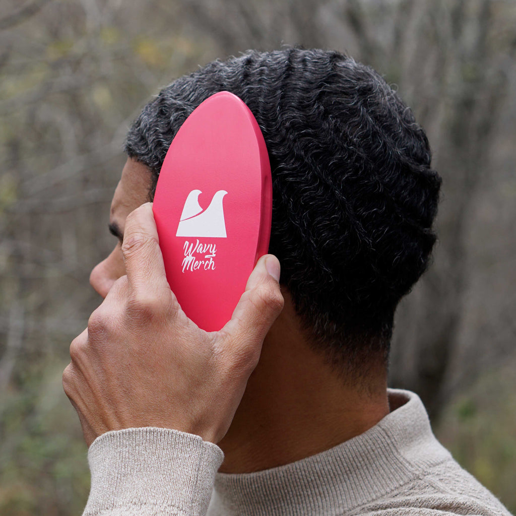 person holding a hard wave brush against their 360 waves