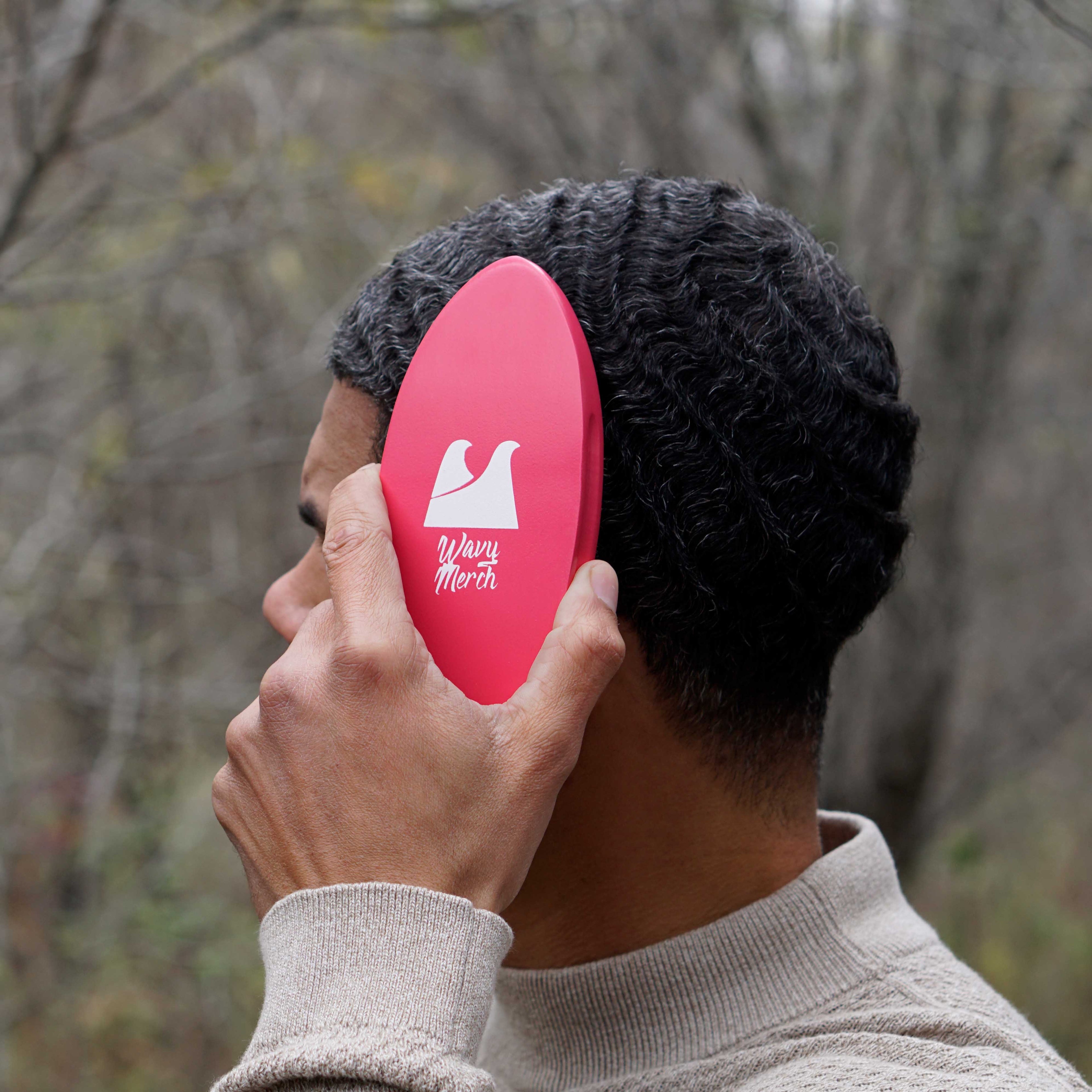 person holding a hard wave brush against their 360 waves